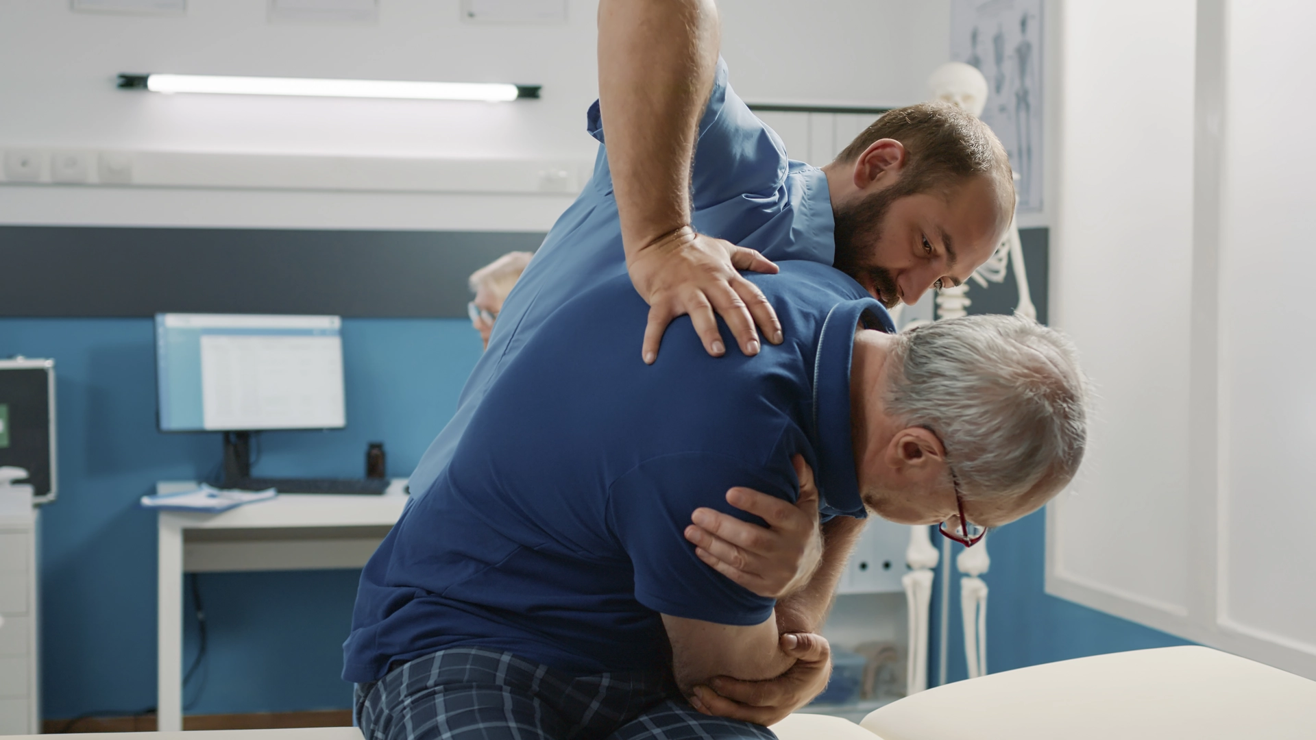 Physical therapist performing manual therapy on a patient's shoulder.